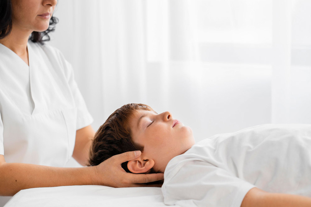 Junge liegt zur Osteopathie auf einer Liege
